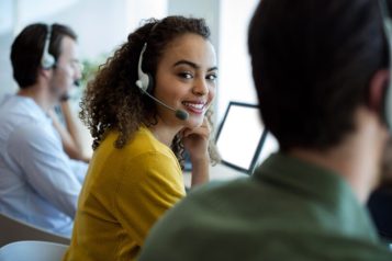 Customer service representative with headset smiling at the camera